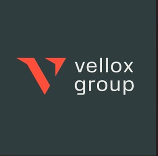 Vellox Group logo with red V-shaped mark and text on dark teal background
